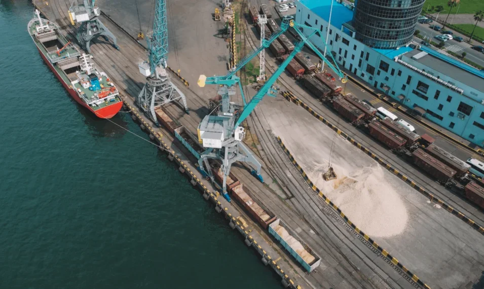 Overview of port with ship docked and freight train present